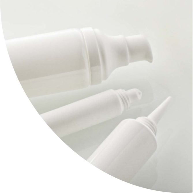Trois tubes en plastique blanc avec des embouts pompes, lipstick et