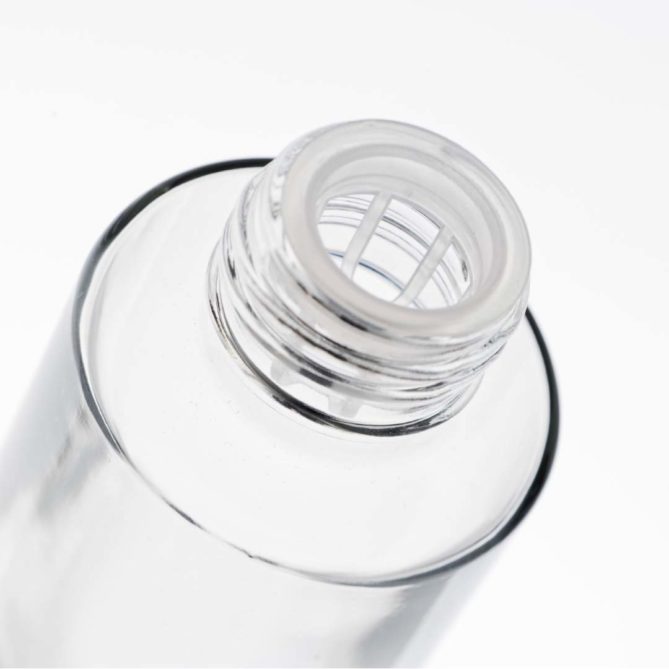 A glass cosmetic bottle to which an accessory called a wringer is screwed