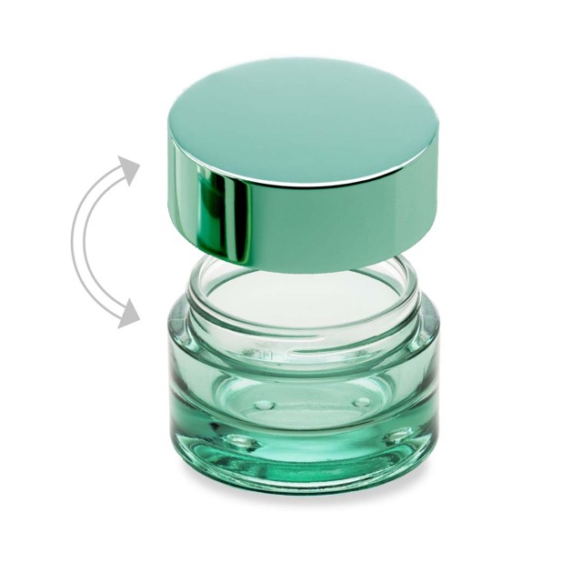 A glass cosmetic jar coloured glass with its green metal lid